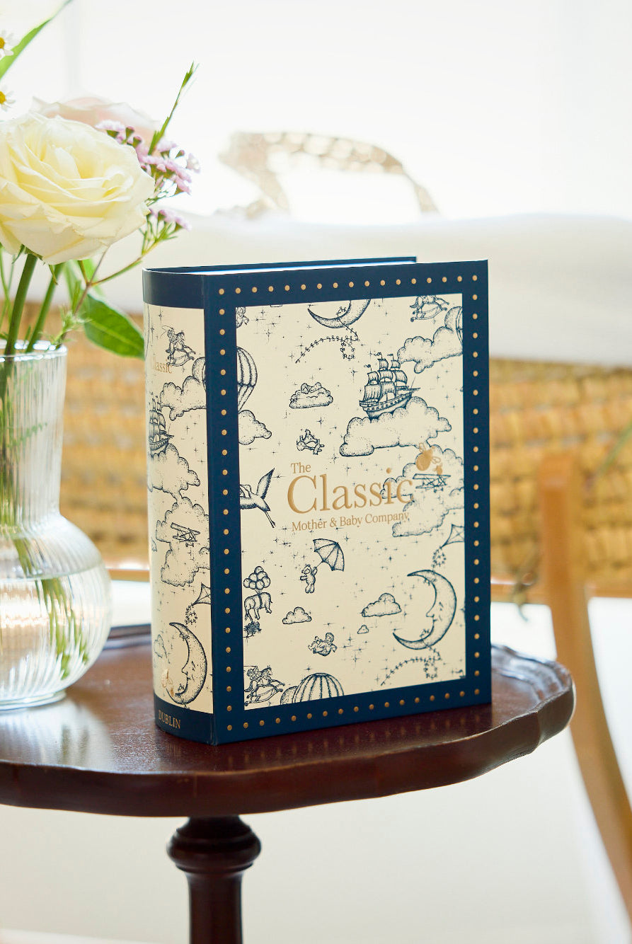 Decorative box with floral design on a small round table in a room.