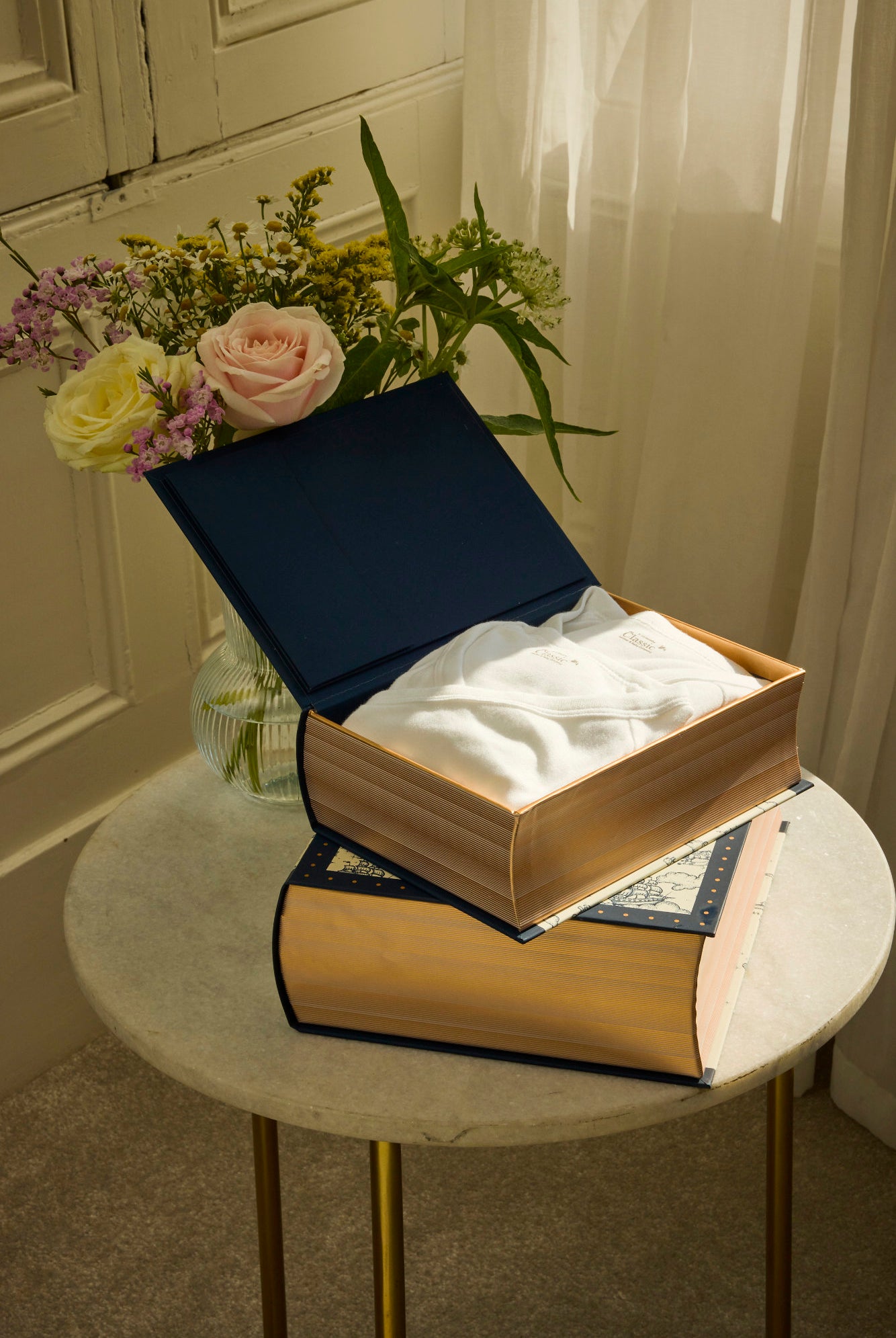 Open box with tissues on a marble table next to flowers
