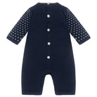 Navy blue baby romper with white button details on a white background