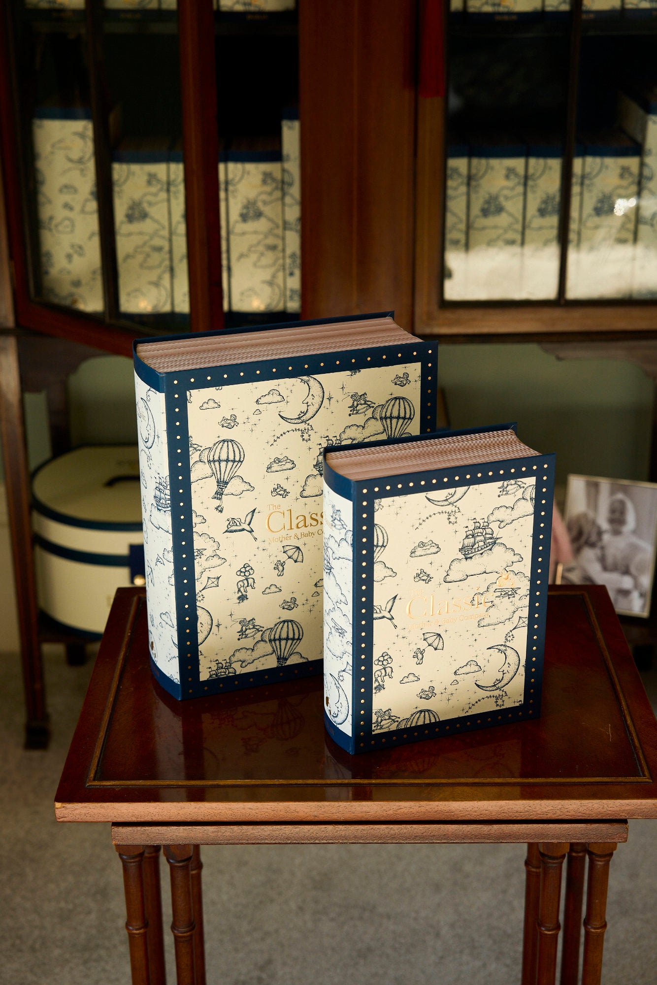 Two decorative books with map design on a wooden table.