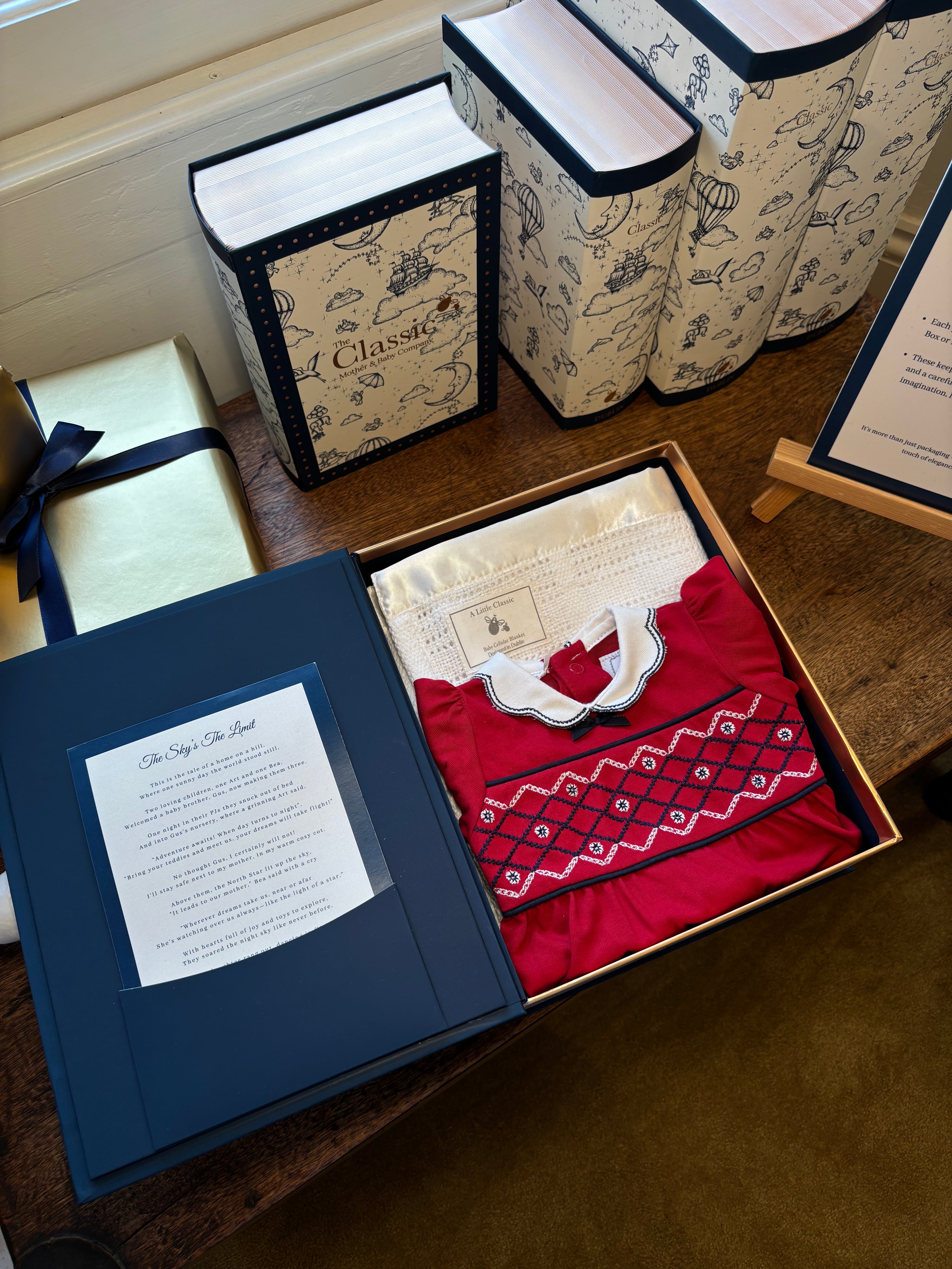 Collection of gift boxes with different designs and one open box revealing a red fabric item.