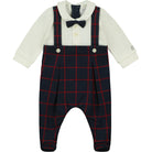 Baby outfit with navy plaid overalls, white shirt, and bow tie on a white background