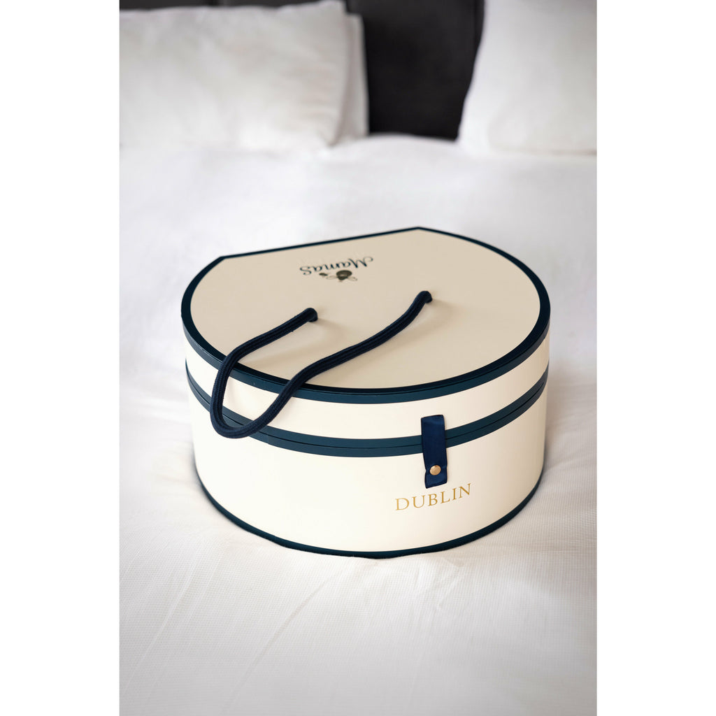cream and navy Hat box gift box on white bed
